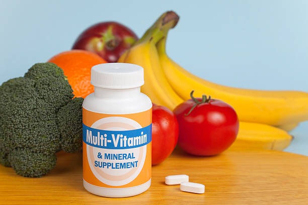 The focus here is on the multi-vitamin bottle and generic label. The tablets contain vitamins and minerals from the surrounding fruit and vegetables.Here are some similar images: