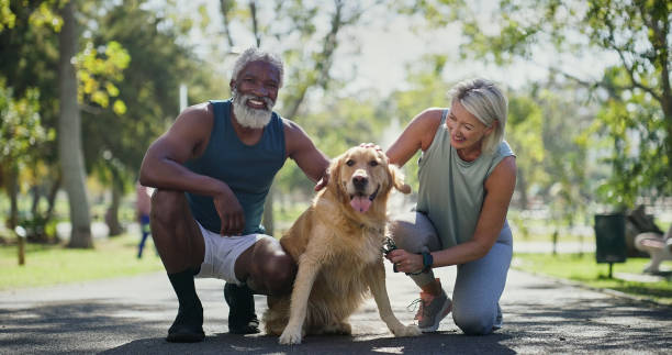 Park, couple and happy with dog for walking or fitness with bonding, support and care. Outdoor, mature people and smile in relationship with pet or animal for adoption with exercise and workout