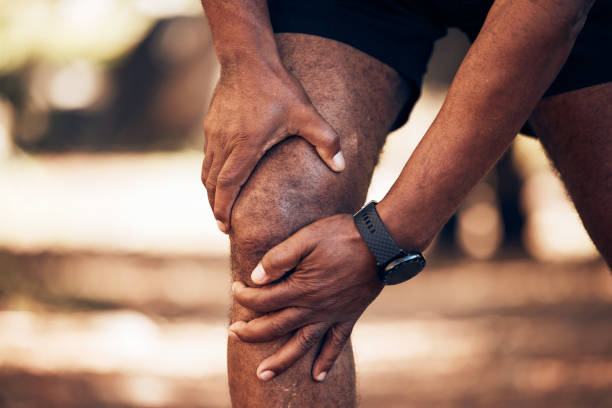 Knee pain, senior hands and injury in nature after accident, workout or training. Sports, athlete health and elderly black man with fibromyalgia, inflammation or tendinitis, arthritis or painful legs