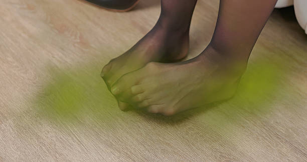 Asian business woman take off high heels and scratch itchy her toes while sitting on sofa at home