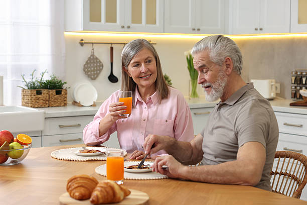 Happy senior couple having breakfast at home
