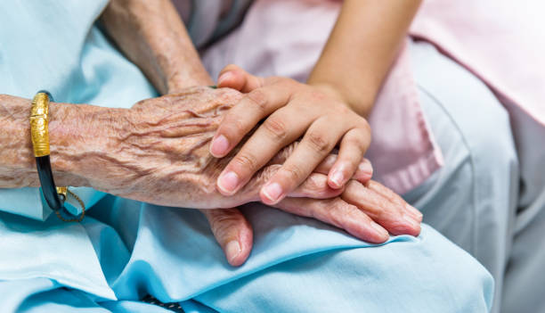 Young woman hand touch and hold an old woman's wrinkled hands
