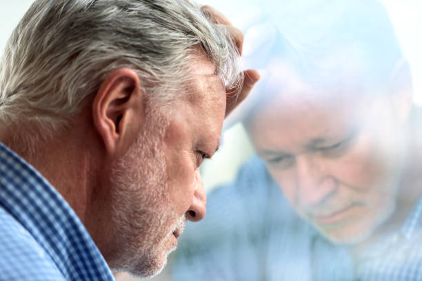 Serious concerned caucasian senior man posing looking down